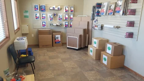 Inside view of a storage office with moving boxes and packing materials for sale.