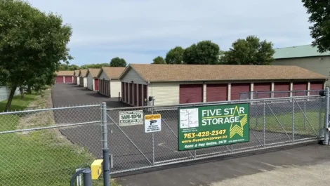Storage facility entrance with a Five Star Storage sign and units behind a fence.