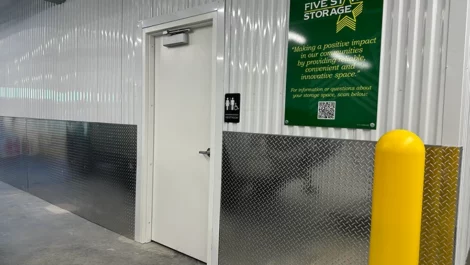 Interior of a storage facility with a Five Star Storage sign and a door.