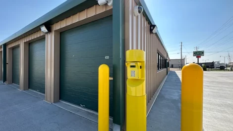 Storage facility with green roll-up doors and a security keypad.