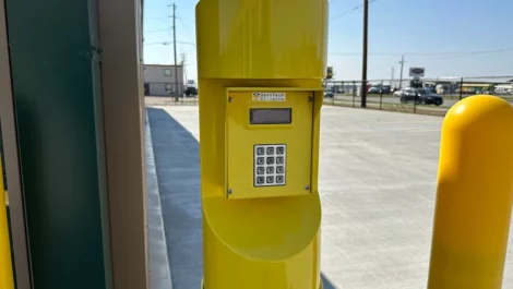 Security keypad on a yellow post providing access to the storage facility.
