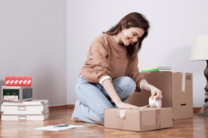 Woman taping storage box.