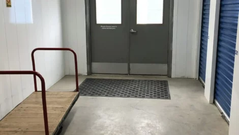 Storage facility hallway with a cart for transporting items to storage units.