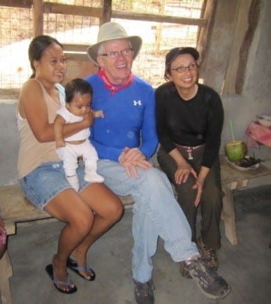 William Schneider, Vice President, with two women and a baby on a mission trip.