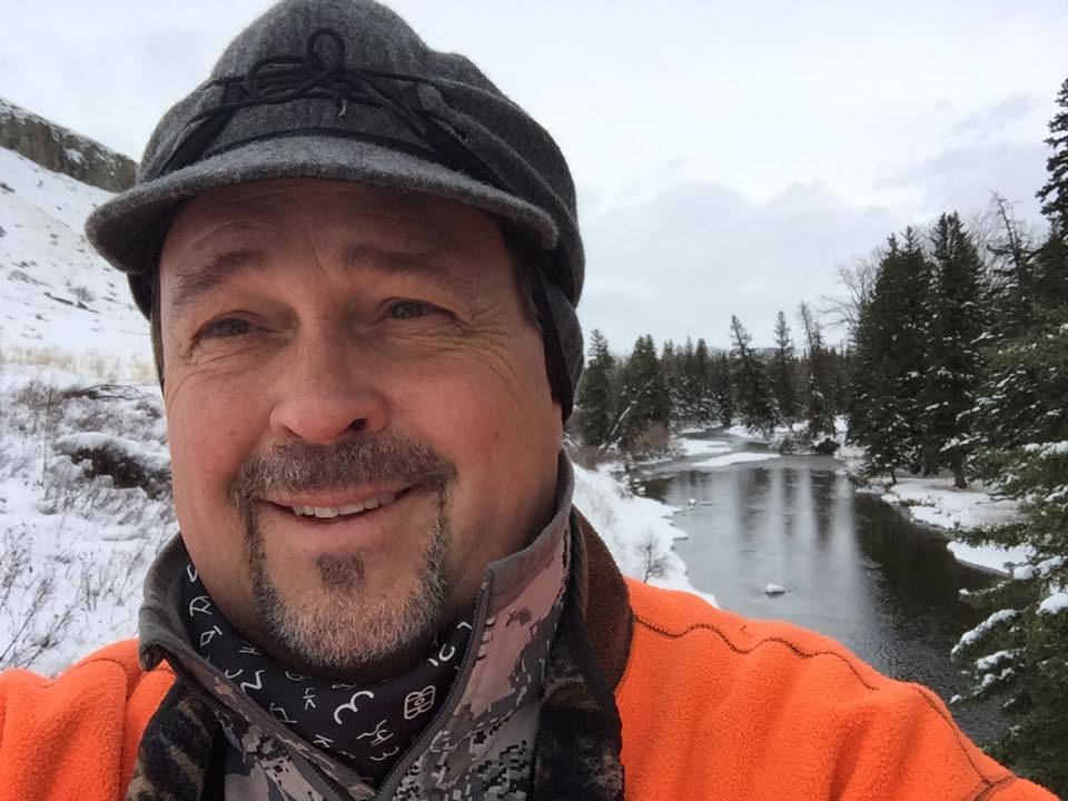 Chuck Hendricks, CEO, outdoor in the snow next to a stream.