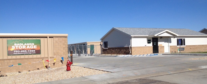 White and stone building with storage units in the background.