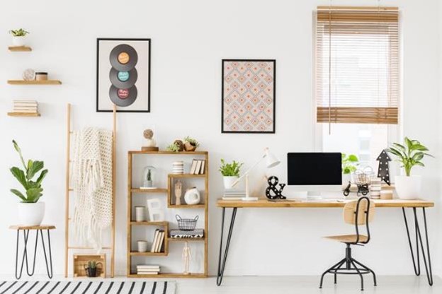 Organized home office setting with desk, computer, chair, shelves, and decorations.