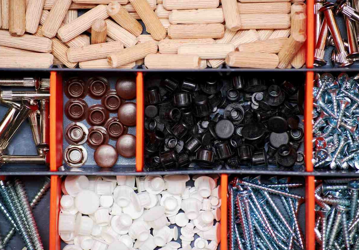 A tool box features small structured boxes filled with dowels, screws, and other various hardware