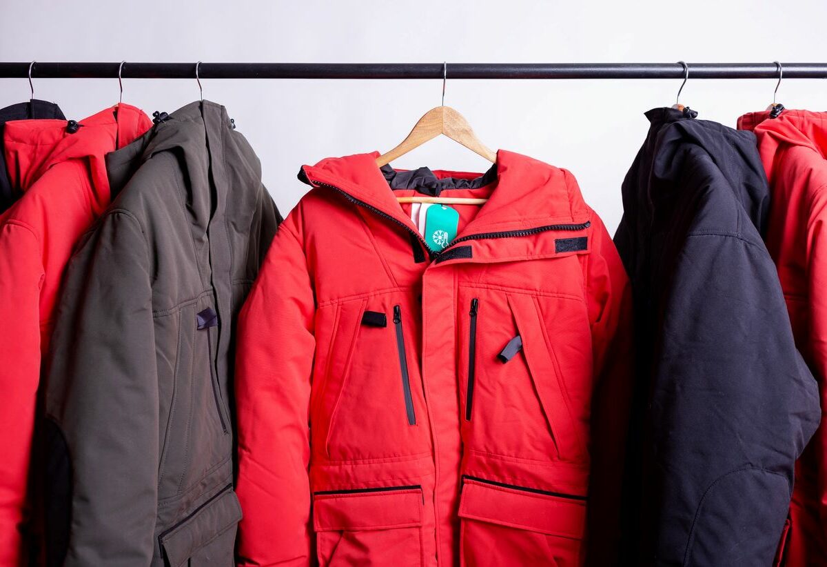 Winter coats and clothing hung up on hangers in the closet.