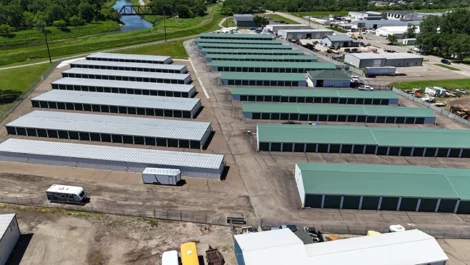 Arial view of neatly arranged storage units with a green landscape.