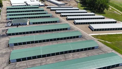 Wide aerial shot of a storage facility with numerous green-roofed storage units.