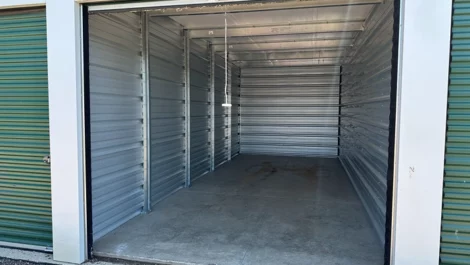 Empty and clean storage unit with a concrete floor and metal paneling.