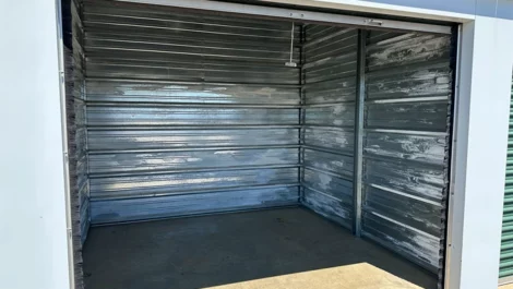 Clean, empty storage unit with a concrete floor and metal paneling.