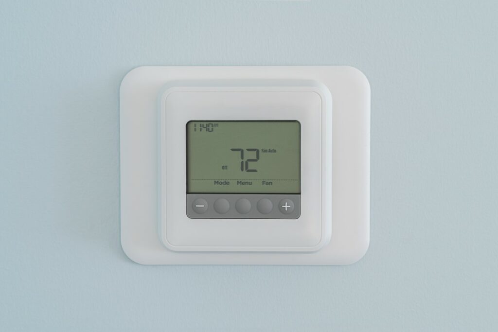 A digital wall thermostat showing a stable temperature on its screen.