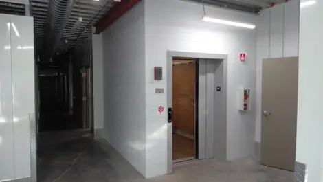 Interior of a storage facility with an elevator and access doors to units.