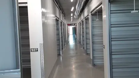 Interior view of a storage facility hallway with numbered units and polished floors.
