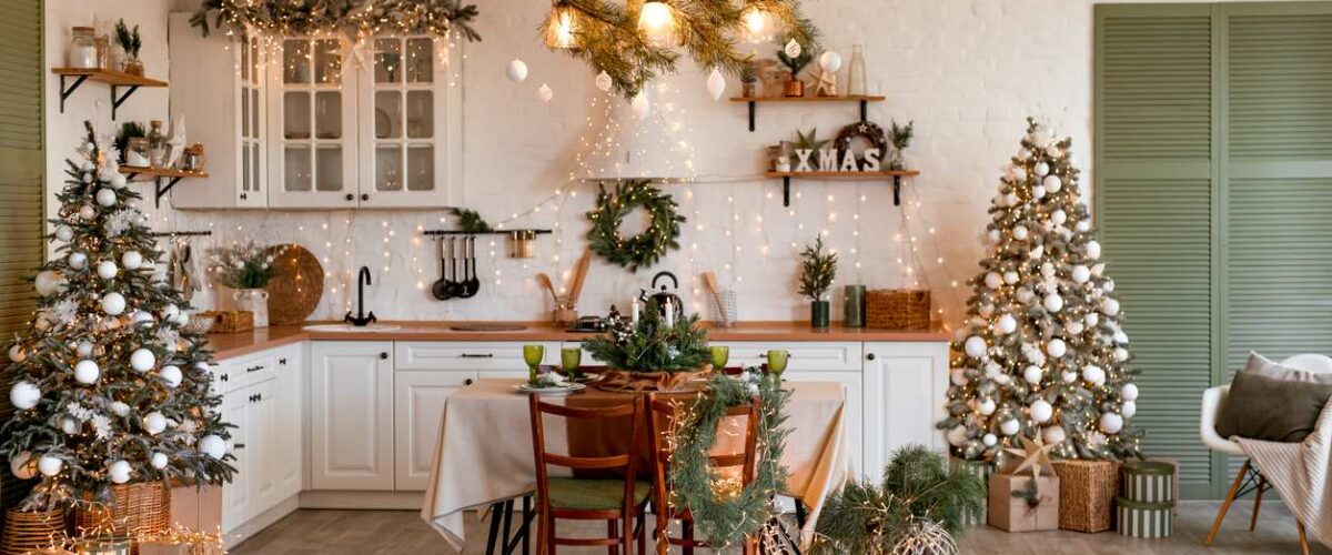 A kitchen with a table decorated with holiday items and lights.