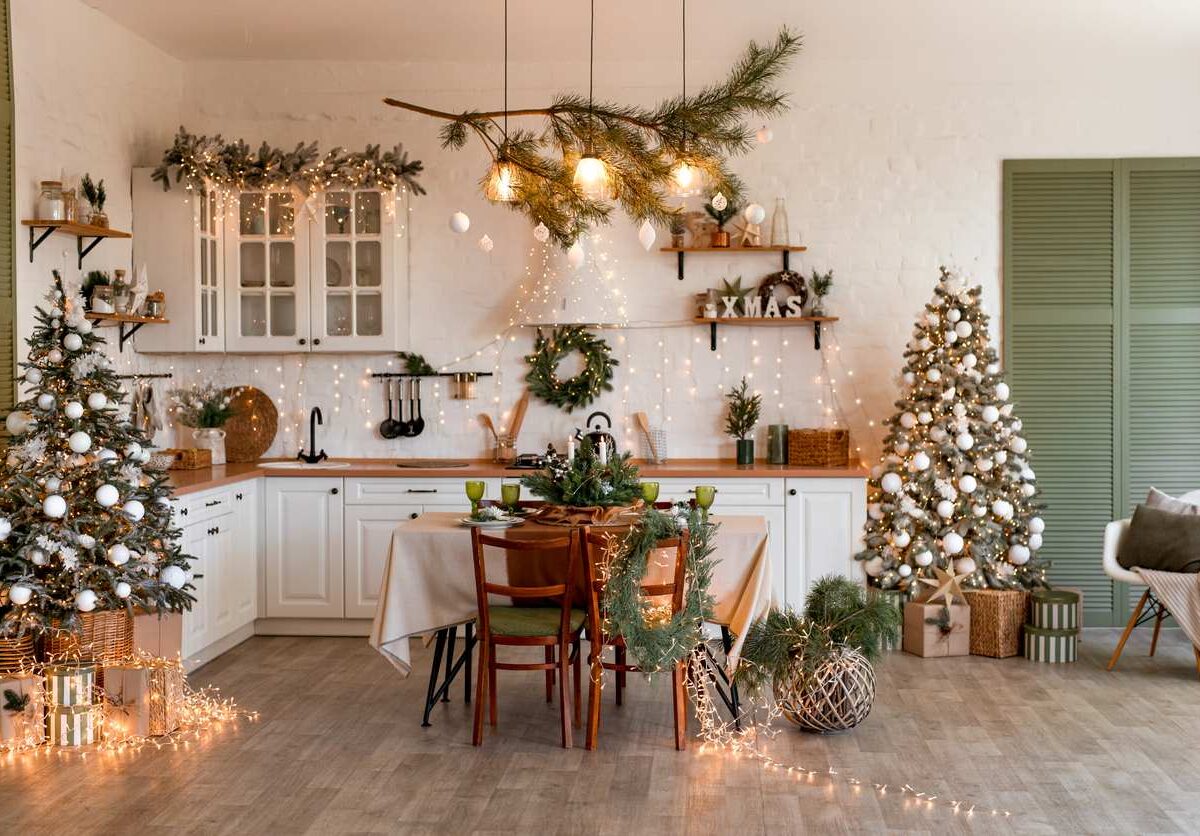 A kitchen with a table decorated with holiday items and lights.