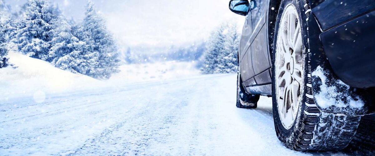 Car tires on a winter road covered with snow.