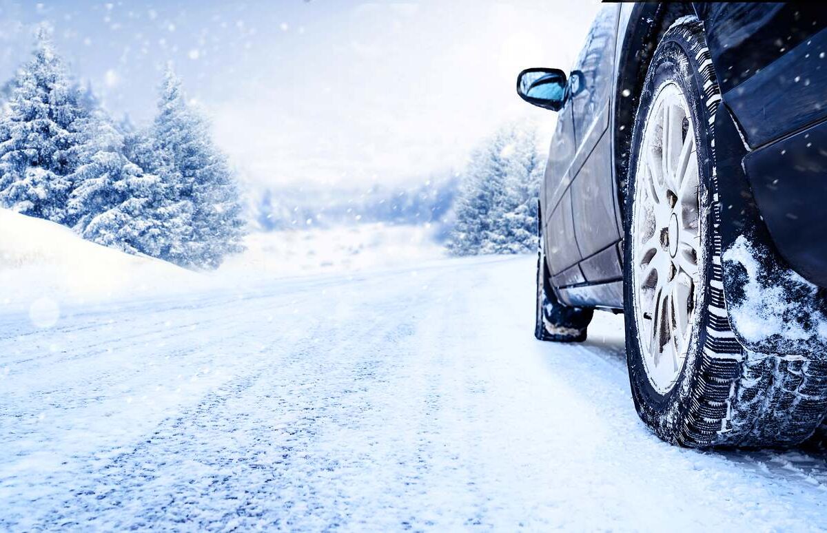 Car tires on a winter road covered with snow.