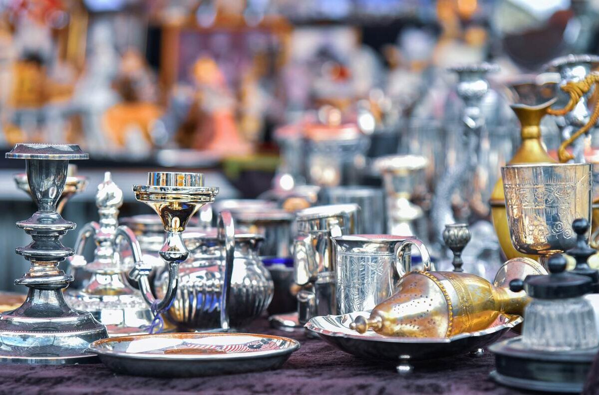 A set of silver items displayed at a yard sale.