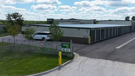 Storage units with a fenced entrance and parking area.